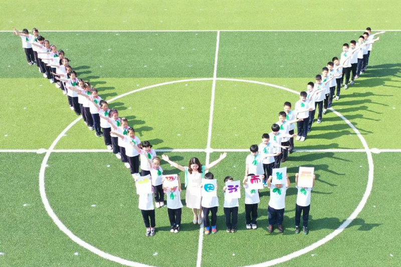 崇明區(qū)東門小學(xué)學(xué)生和老師們擺出一對(duì)翅膀，振翅欲飛。（來源：上海教育微信公眾號(hào)）