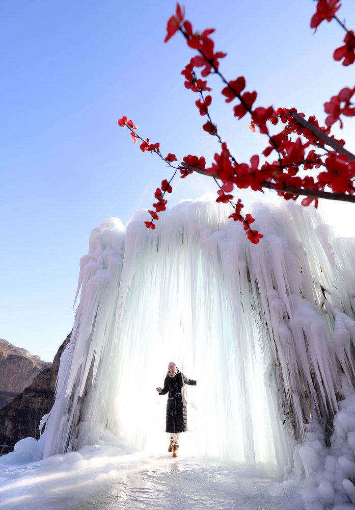 12月16日，在河北省平山縣沕沕水景區(qū)，游客在冰瀑中穿梭游玩。