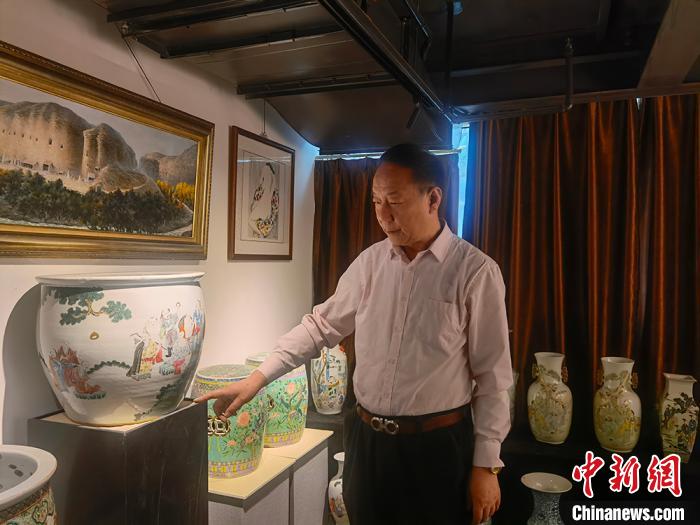 劉世杰向記者介紹自己收藏的文物?！「呖档?攝