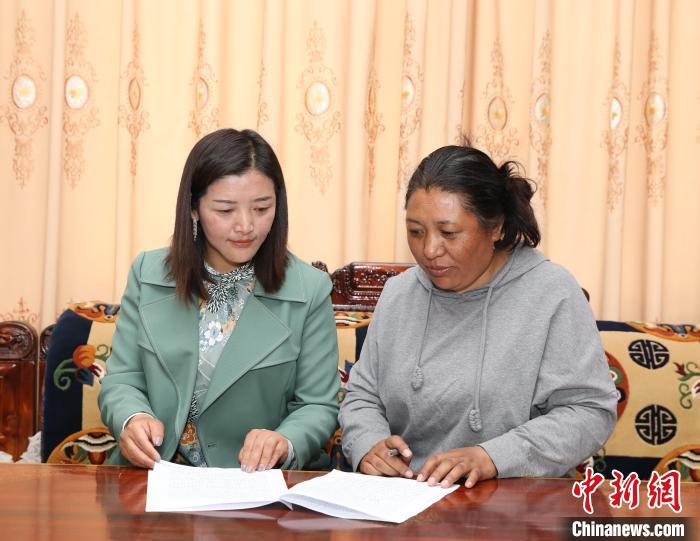 圖為扎囊養(yǎng)護段段長次旦卓瑪(左)正在與同事交流工作?！≮w延 攝